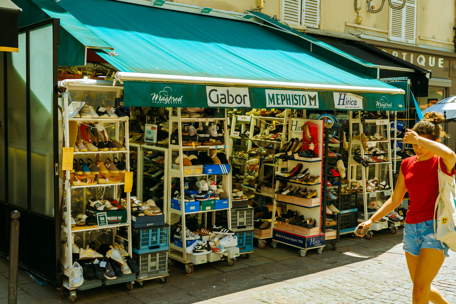 A sunlit neighborhood kiosk with a deep green awning.