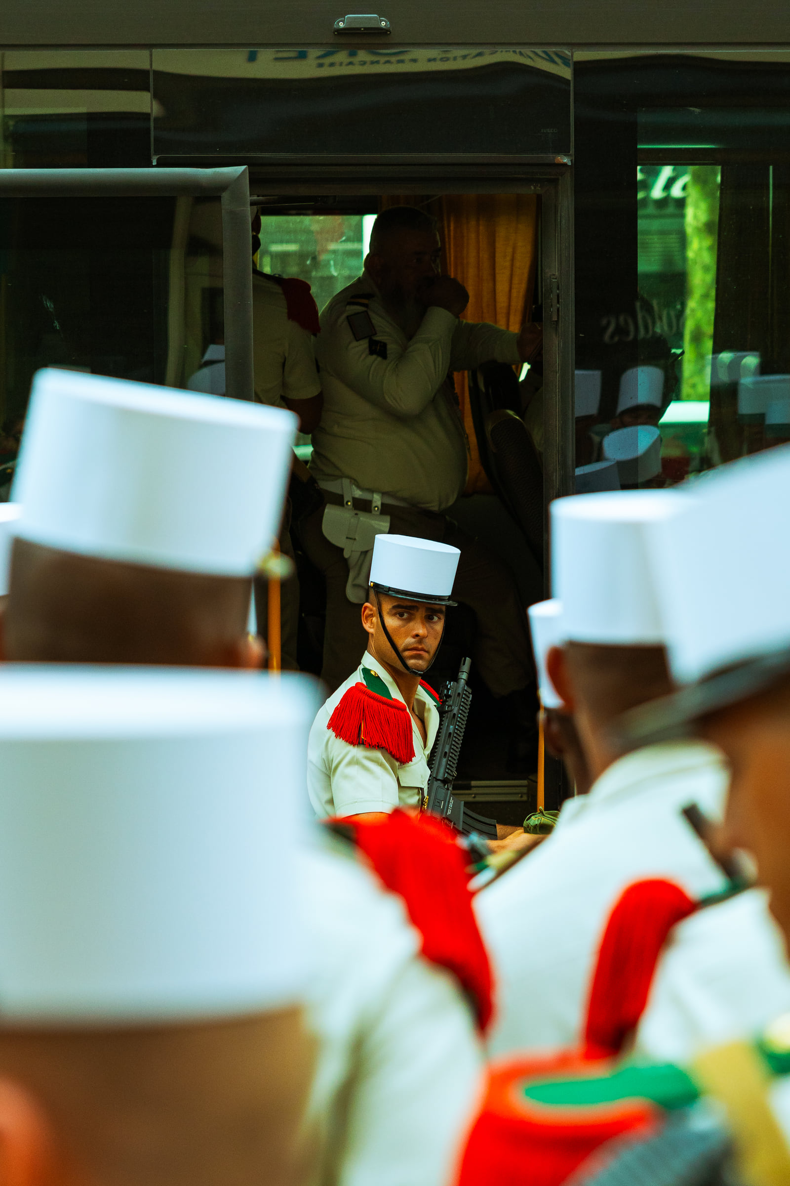 A café worker in red glimpsed between white chairs.