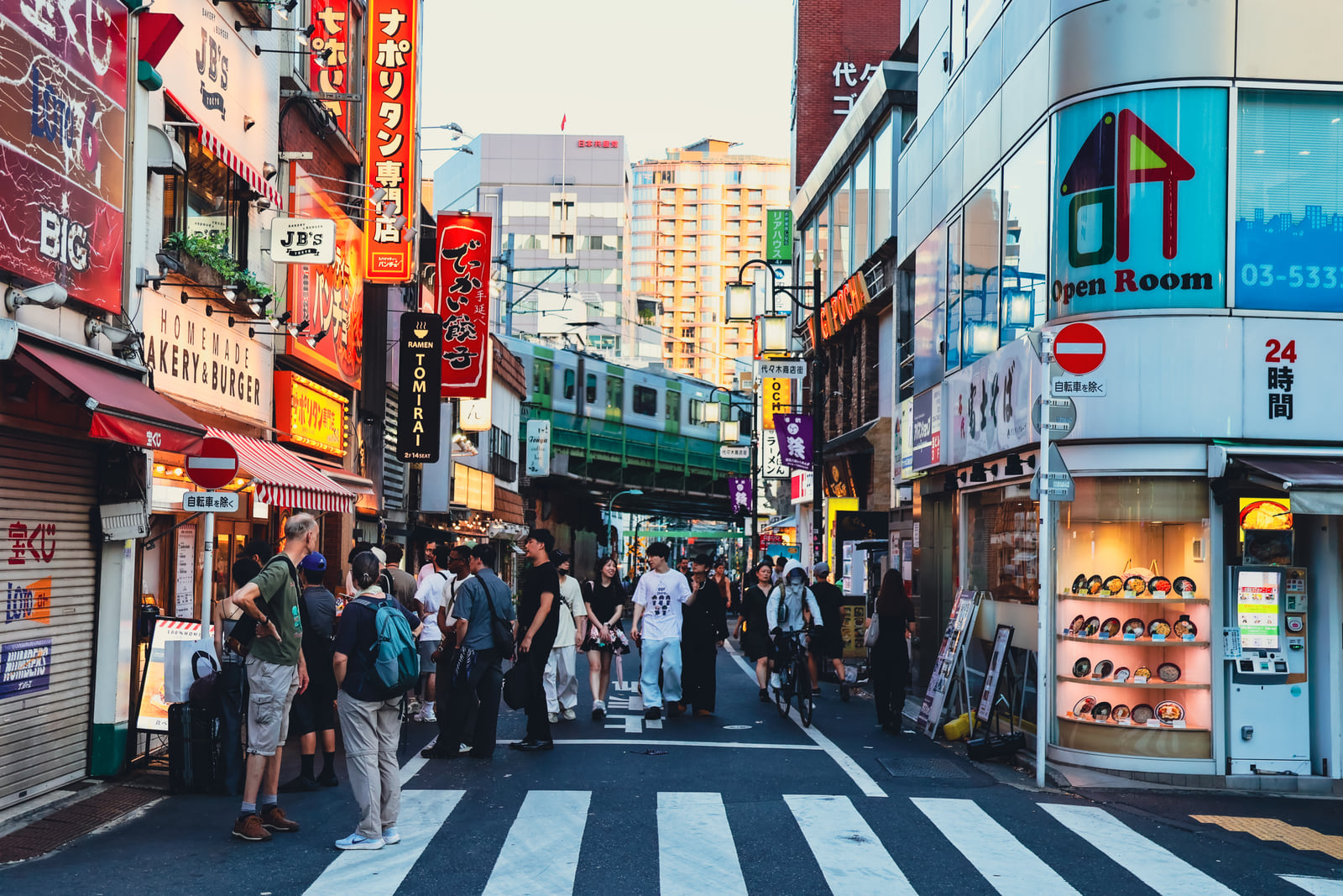 A lively commercial street filled with red signs and pedestrians.