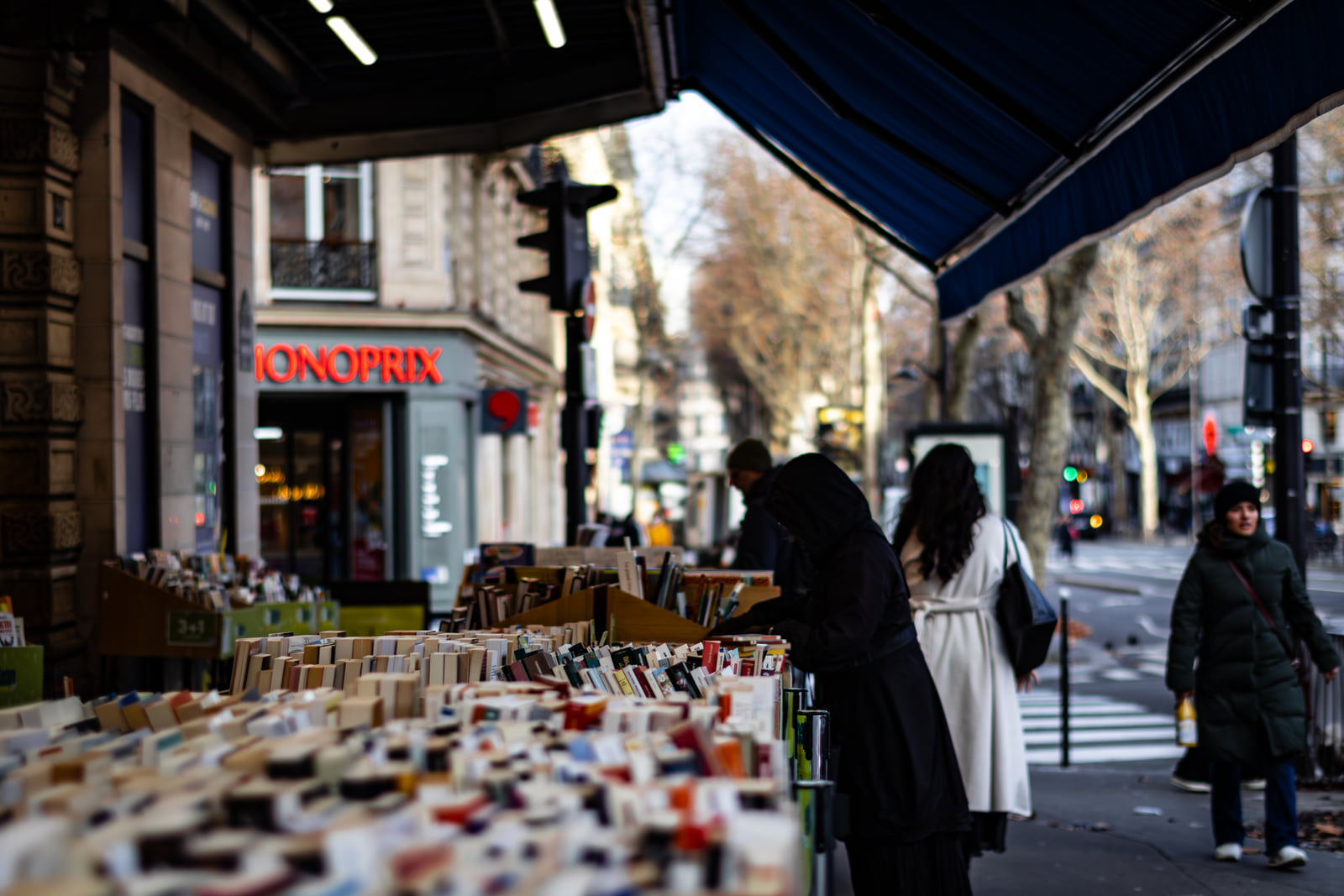 An eyewear stall seen beneath a dark awning at a city corner.